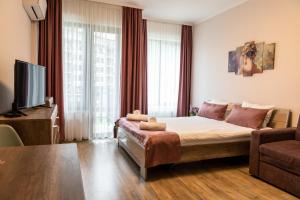 uma sala de estar com uma cama e uma televisão em Апартамент и Студия "Спа Вълшебство" em Velingrad