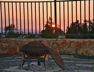 una parrilla frente a una valla con la puesta de sol en Gilboa Siesta / סייסטה בגלבוע en Nurit