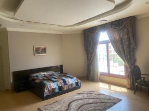 1 dormitorio con cama y ventana grande en Super luxurious villa with large landscape areas, en El Cairo