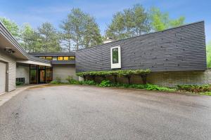 een huis met een zwart dak en een oprit bij Modern Style Lakefront Retreat in Stevens Point