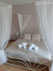 una camera da letto con letto e tende bianche di fragole e menta ad Attimis