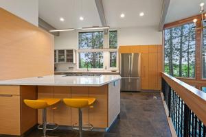 uma cozinha com uma ilha com bancos amarelos em Modern Style Lakefront Retreat em Stevens Point