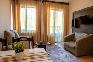 a living room with a couch and a chair and a table at Апартамент и Студия "Спа Вълшебство" in Velingrad