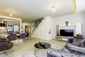 ein Wohnzimmer mit Sofas, einem TV und einer Treppe in der Unterkunft Sea View Stylish Flat w Shared Pool in Alanya in Çamyolu