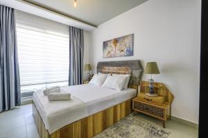 ein Schlafzimmer mit einem großen Bett und einem Fenster in der Unterkunft Sea View Stylish Flat w Shared Pool in Alanya in Çamyolu