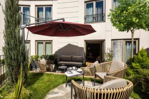a patio with a table and chairs and an umbrella at CVK Park Bosphorus Hotel Istanbul in Istanbul +37 photos
