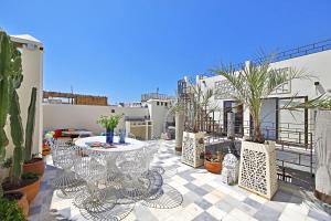 eine Terrasse mit einem Tisch, Stühlen und Pflanzen in der Unterkunft Riad EspritBleu in Essaouira