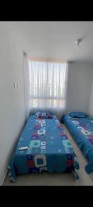 a bedroom with two twin beds in it at Apartamento en Condomio Peñazul La Aldea en Ricaurte - Girardot in Ricaurte