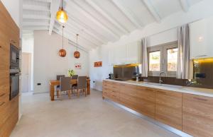 cocina con armarios de madera y mesa de comedor en Simpson Secret Corfu, en Nisakion