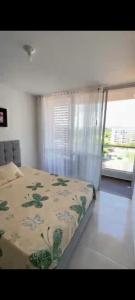 a bedroom with a bed with a floral bedspread at Apartamento en Condomio Peñazul La Aldea en Ricaurte - Girardot in Ricaurte
