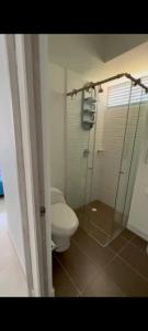a bathroom with a toilet and a glass shower at Apartamento en Condomio Peñazul La Aldea en Ricaurte - Girardot in Ricaurte