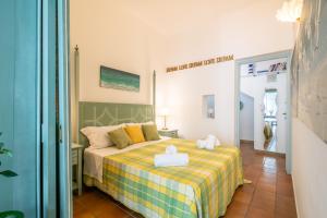 1 dormitorio con 1 cama con manta amarilla y verde en Colors House On The Beach, en Calambrone