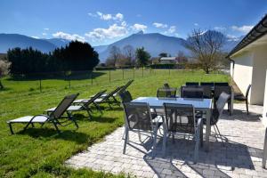 un grupo de sillas y una mesa en un campo en Le Gîte la PasserELLE se situant dans le Trièves dans l Isère pour 14 personnes, en Lavars