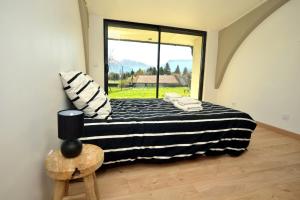 1 dormitorio con cama y ventana grande en Le Gîte la PasserELLE se situant dans le Trièves dans l Isère pour 14 personnes, en Lavars