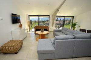 Sala de estar con 2 sofás y mesa en Le Gîte la PasserELLE se situant dans le Trièves dans l Isère pour 14 personnes, en Lavars