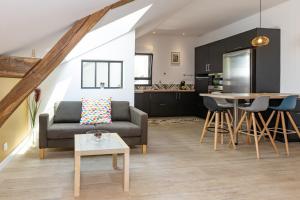 a living room with a couch and a table at Le Cri de la Chouette - Appt avec terrasse in La Chapelle-Thouarault +8 photos