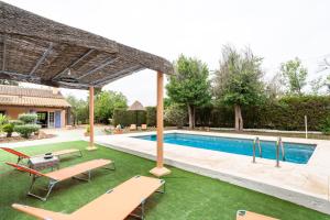 a swimming pool with two chairs and a table and a pool at Villa Laforge in Carmona