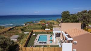 an aerial view of a house with a swimming pool and the ocean at Aktis Elegant Villa in Alikanas