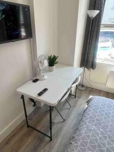 a white desk in a room with a window at Cosy studio flat In teddington in Teddington