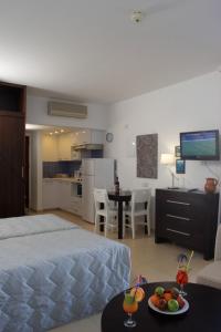 a bedroom with a bed and a table with a plate of fruit at MarisMare Apartments in Ayia Napa