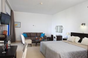 Habitación de hotel con cama y sofá en MarisMare Apartments, en Ayia Napa