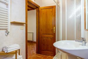 a bathroom with a sink and a wooden door at Geranio - Agriturismo La Fattoria in Grosseto