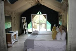 een slaapkamer met een groot bed in een tent bij Lions Rock Rapids - Lodge in Hazyview
