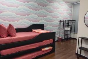 ケパラ・バタスにあるTamu d'Bertam Homestayのベッドルーム1室(壁に雲が描かれたベッド1台付)