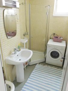 a bathroom with a sink and a washing machine at Apartman Amigo-Free public parking in Sarajevo