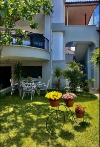 dziedziniec ze stołem, krzesłami i kwiatami w obiekcie Anemos Apartment w mieście Keramotí