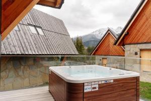 a jacuzzi tub on a deck with a view at Landscape Zakopane by LoftAffair in Kościelisko