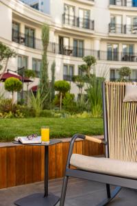 uma cadeira e uma mesa com um copo de sumo de laranja em CVK Park Bosphorus Hotel Istanbul em Istambul