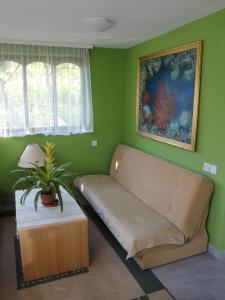 een woonkamer met een bank in een groene muur bij Blumauer Apartments in Ljubljana