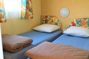 um quarto com duas camas individuais num quarto em CAMPING VERT LAVANDE em Belmont-sur-Rance