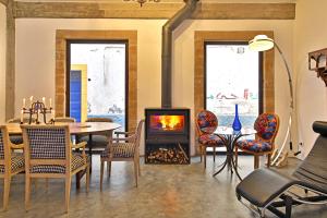 a living room with a fireplace and a table and chairs at Riad EspritBleu in Essaouira