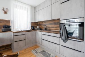 eine Küche mit Küchengeräten aus Edelstahl und einem Fenster in der Unterkunft Alpensafari Design Appartment in Bad Kleinkirchheim