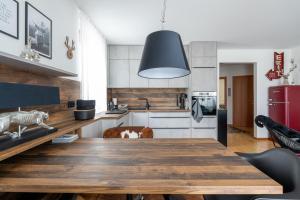 eine Küche mit einem Holztisch und einem schwarzen Anhängerlicht in der Unterkunft Alpensafari Design Appartment in Bad Kleinkirchheim