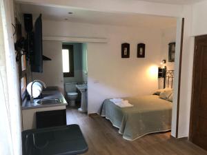 1 dormitorio con cama, lavabo y baño en Hostal-Restaurante Fogón de Gredos, en Guisando