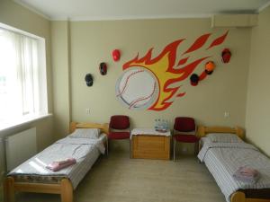 two beds in a room with a baseball on the wall at Rojupe in Roja