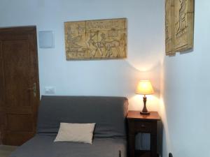 a bedroom with a bed with a lamp and a painting on the wall at Hostal-Restaurante Fogón de Gredos in Guisando