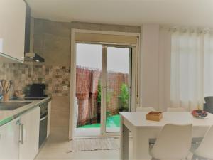 een keuken met een tafel en een glazen deur bij Apartamento Breogan Coruña in A Coruña +9 foto's