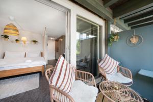 Zimmer mit einem Bett und Stühlen auf einem Balkon in der Unterkunft "Boho Oase" with lake view and pool in Därligen