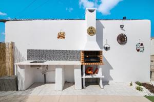 een huis met een pizzaoven op een patio bij Horta Teresa in Quarteira