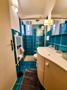 bagno con lavandino, servizi igienici e piastrelle blu di Residenza Palmira Bardolino a Calmasino