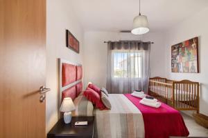 een slaapkamer met een bed met een wieg en een raam bij Horta Teresa in Quarteira