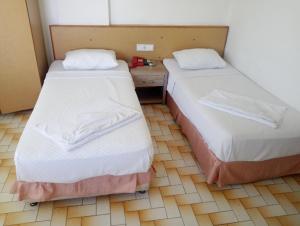a room with two beds and a table in it at Hotel Yildirimoglu in Alanya