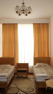um quarto com 2 camas e um lustre em YMCA Spitak em Spitak