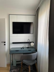 einen Schreibtisch mit Stuhl und einen TV an der Wand in der Unterkunft Apartman Eva, moderan stan u srcu Zagorja in Krapina