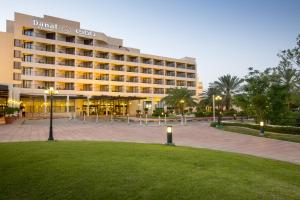 un hôtel avec une pelouse devant un bâtiment dans l'établissement Danat Al Ain Resort, à Al-Aïn