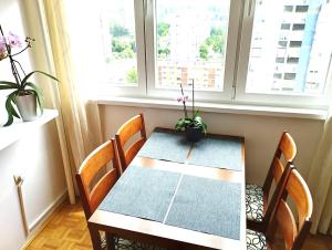 a table and chairs in a room with windows at Apartman Amigo-Free public parking in Sarajevo